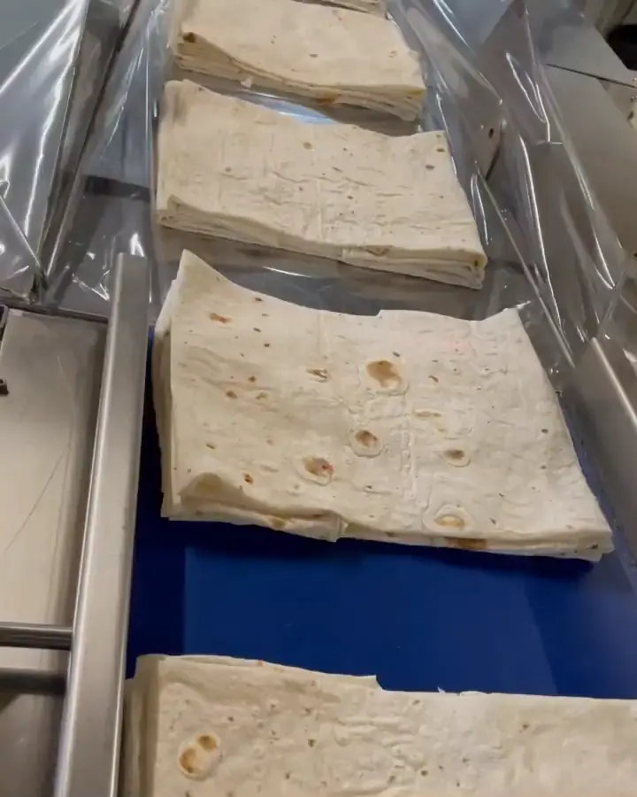 Paquets de yufka pliés sur le tapis bleu, en route sous le film